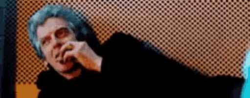 a close up of a man smoking a cigarette in a room .