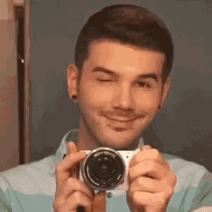 a young man is taking a picture of himself with a camera
