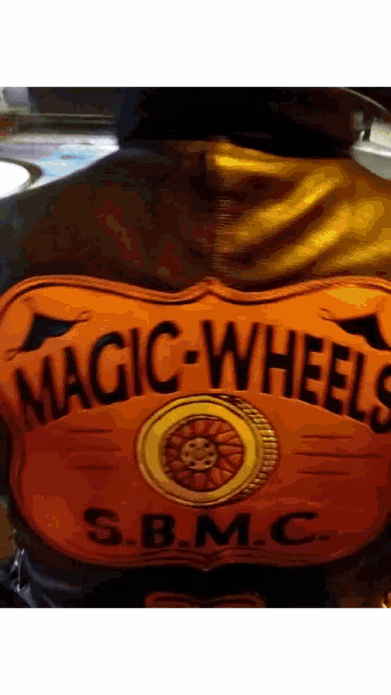 a person wearing a jacket that says magic wheels s.b.m.c