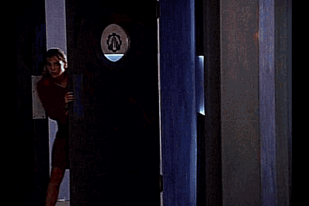 a woman is standing in a hallway in front of a sign that says ' laboratory ' on it .