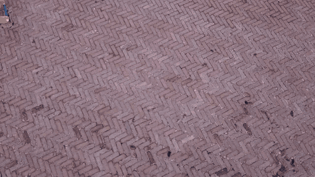 a man 's hand is reaching out towards a brick floor