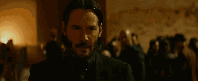 a man with a beard is standing in front of a crowd of people .