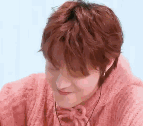 a close up of a person wearing a pink sweater .