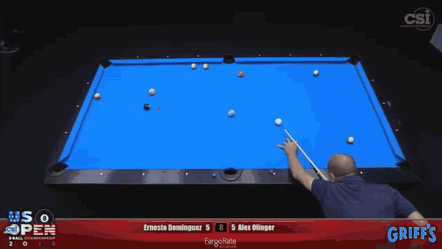 a pool table with a man holding a cue and a scoreboard that says griffs
