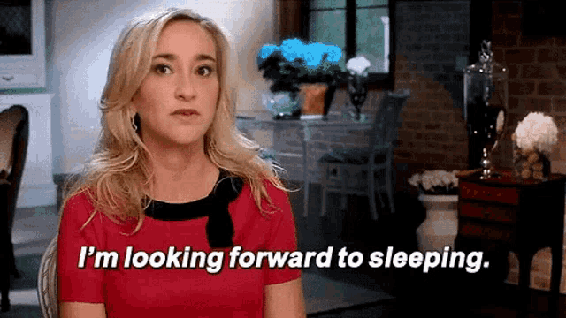 a woman in a red shirt is looking forward to sleeping