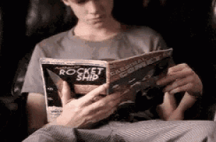 a man is reading a magazine that says rocket ship