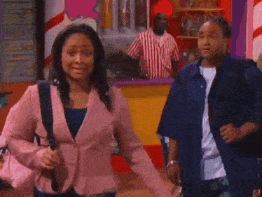 a woman in a pink jacket is standing next to a man in a blue shirt in front of an ice cream parlor .