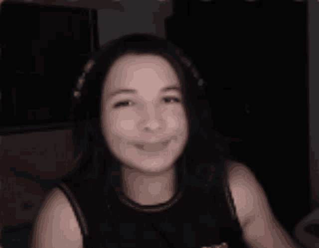 a woman wearing headphones looks at the camera