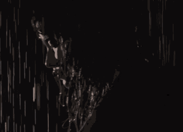 a woman 's face is visible in the dark as rain drops fall on it