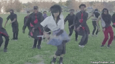 a group of people are dancing in a field while wearing ninja costumes .