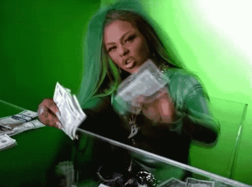 a woman in a green dress is holding a bunch of money in front of a mirror .