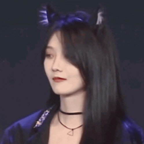 a close up of a woman wearing a cat ear headband and a choker necklace .