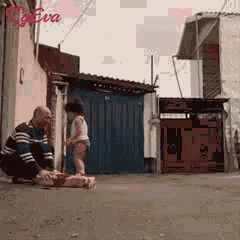 a man is kneeling down next to a little girl in front of a building with the word eva on it