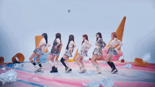 a group of girls are dancing in front of ice cream cones and ice cubes