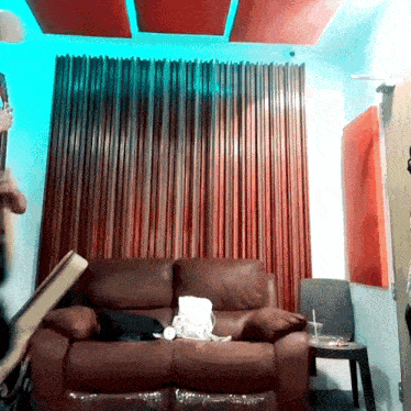 a man playing a guitar in a room with a couch