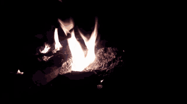 a fire is burning in the dark with a blue flame coming out of it