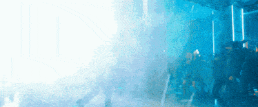 a group of people are standing in a dark room with smoke coming out of it