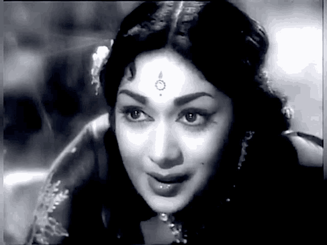 a black and white photo of a woman 's face with a bindi on her forehead