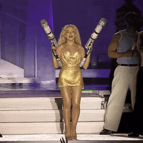 a woman in a gold dress holds a pair of cigarettes over her shoulder