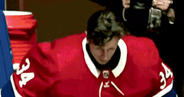 a hockey player with the number 34 on his red jersey