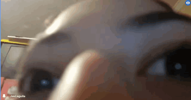 a close up of a person 's eyes with the name javi aguila on the bottom