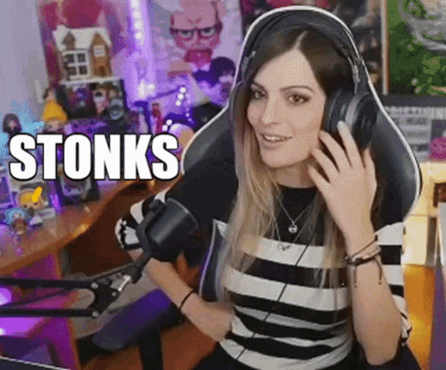 a woman wearing headphones is sitting in front of a microphone with the word stonks written on it