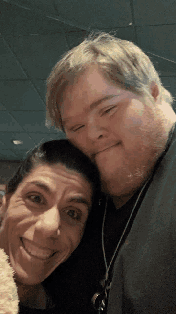 a man with down syndrome and a woman smile for a picture