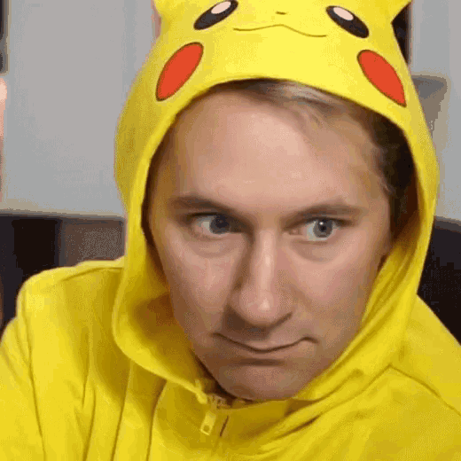 a man is wearing a pikachu hoodie and making a funny face