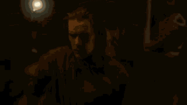 a close up of a person holding a gun in a dark room with a light coming out of it .