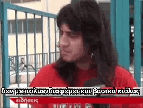 a man with long hair is talking into a microphone in a foreign language .