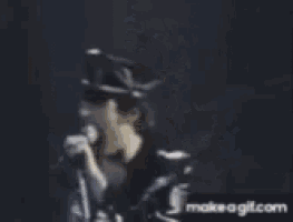 a man in a police hat is singing into a microphone