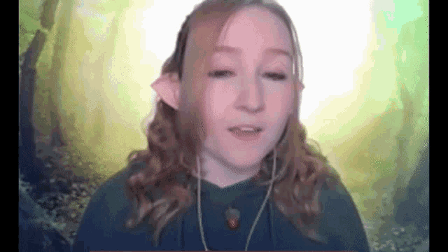 a girl wearing ear plugs and a necklace is talking on a video call