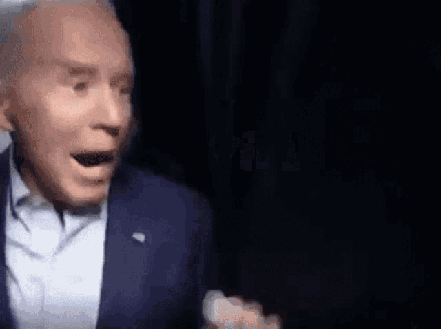 a man in a suit and tie is making a funny face while talking on a video call .