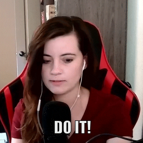 a woman wearing headphones and a red shirt is sitting in front of a microphone .