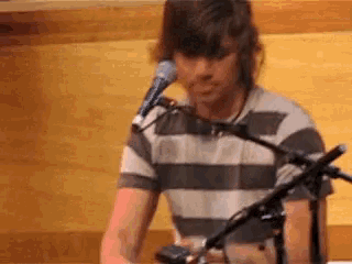 a man is playing a keyboard and singing into a microphone .