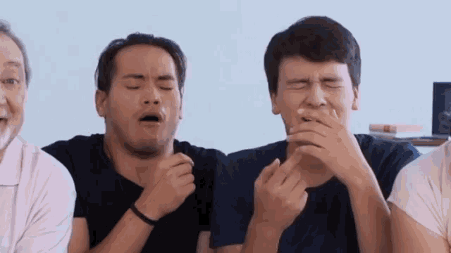 a group of young men are covering their mouths