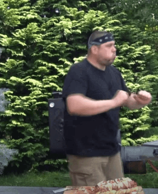 a man wearing a headband is dancing in front of a stack of pizzas