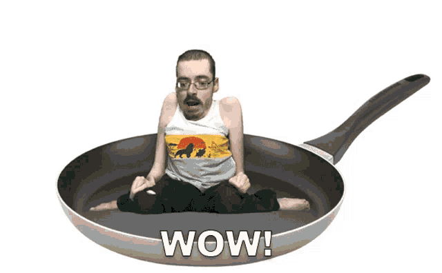 a man is sitting in a frying pan with the word wow written on it
