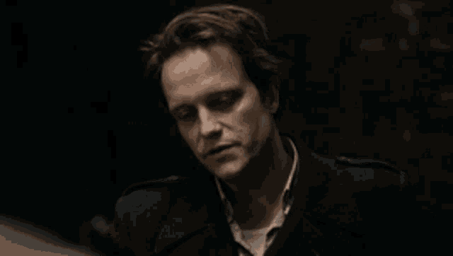 a close up of a man 's face in a dark room .