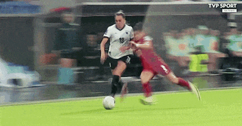two women are playing soccer and one has the number 18 on her jersey .
