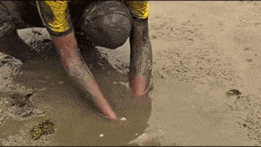 a person is kneeling in a puddle of water .