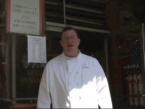 a man in a white chef 's coat stands in front of a sign that says king restaurant