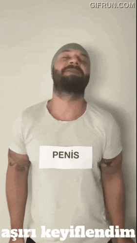 a man with a beard is wearing a white t-shirt that says penis