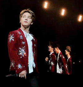 a young man in a red jacket with silver stars on it