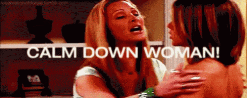 two women are standing next to each other in a room and one of them is screaming at the other .