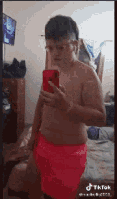 a shirtless man is taking a picture of himself with his phone