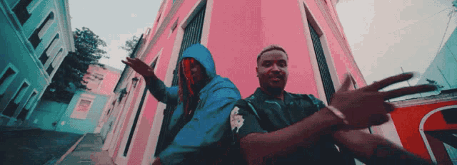 a man in a blue hoodie is standing next to another man