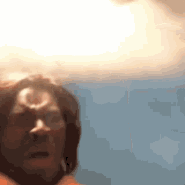 a close up of a person 's face with a light coming out of his head .