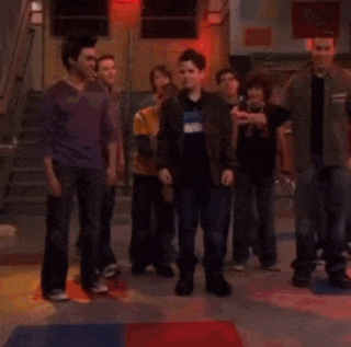 a group of people are standing in a hallway with a chair in the foreground .