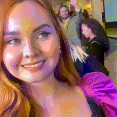 a woman in a purple dress is taking a picture of herself
